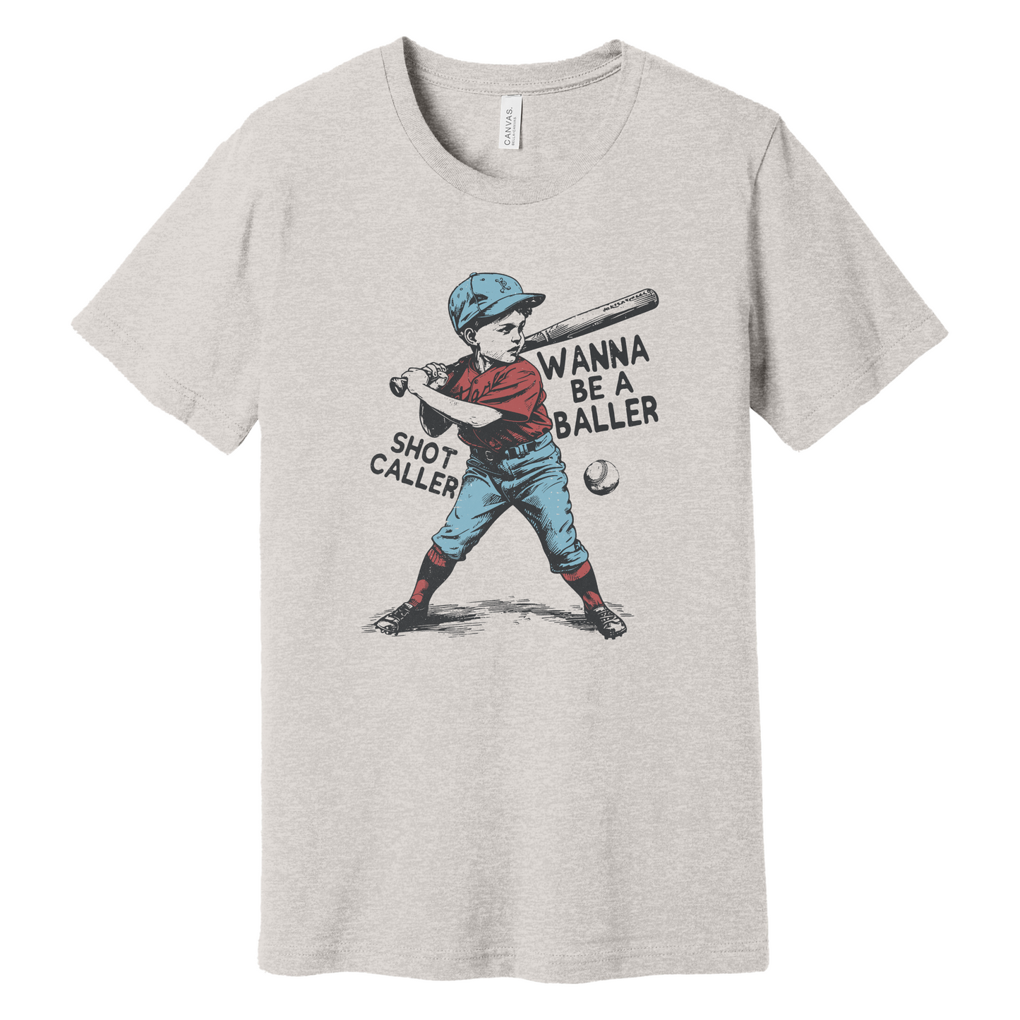 A natural-colored T-shirt in a soft heathered finish, featuring a vintage-style graphic of a young baseball player at bat. The design includes the phrases 'Wanna Be a Baller' and 'Shot Caller' in bold black text, giving the shirt a playful, retro vibe perfect for baseball lovers.