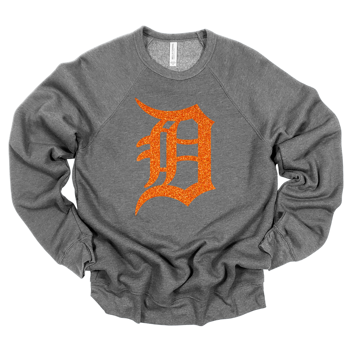 A gray crewneck sweatshirt featuring a bold, glitter-textured ‘D’ in a classic Detroit-style font. The design is shown in orange glitter, adding a sparkling touch to a sporty and stylish look.