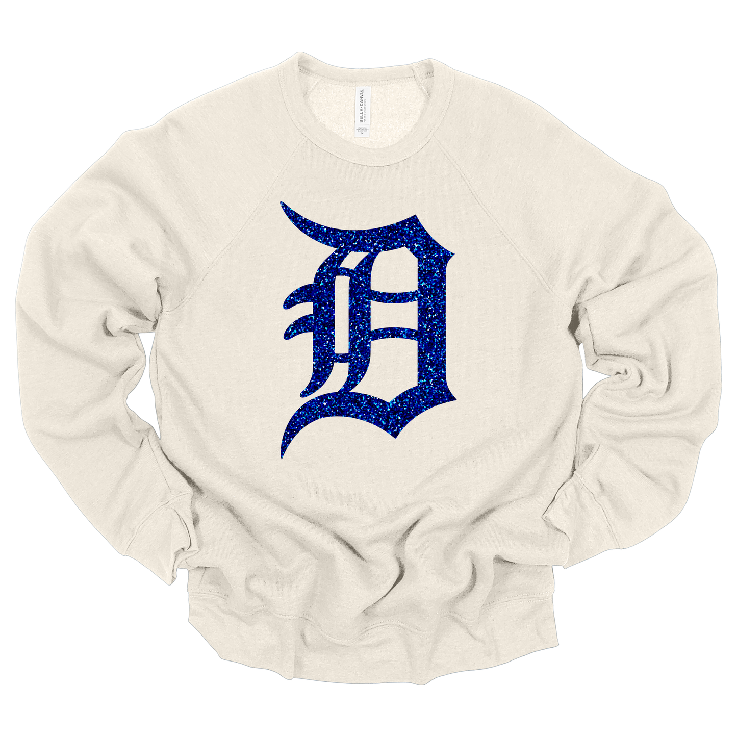 A dust colored crewneck sweatshirt featuring a bold, glitter-textured ‘D’ in a classic Detroit-style font. The design is shown in blue glitter, adding a sparkling touch to a sporty and stylish look.