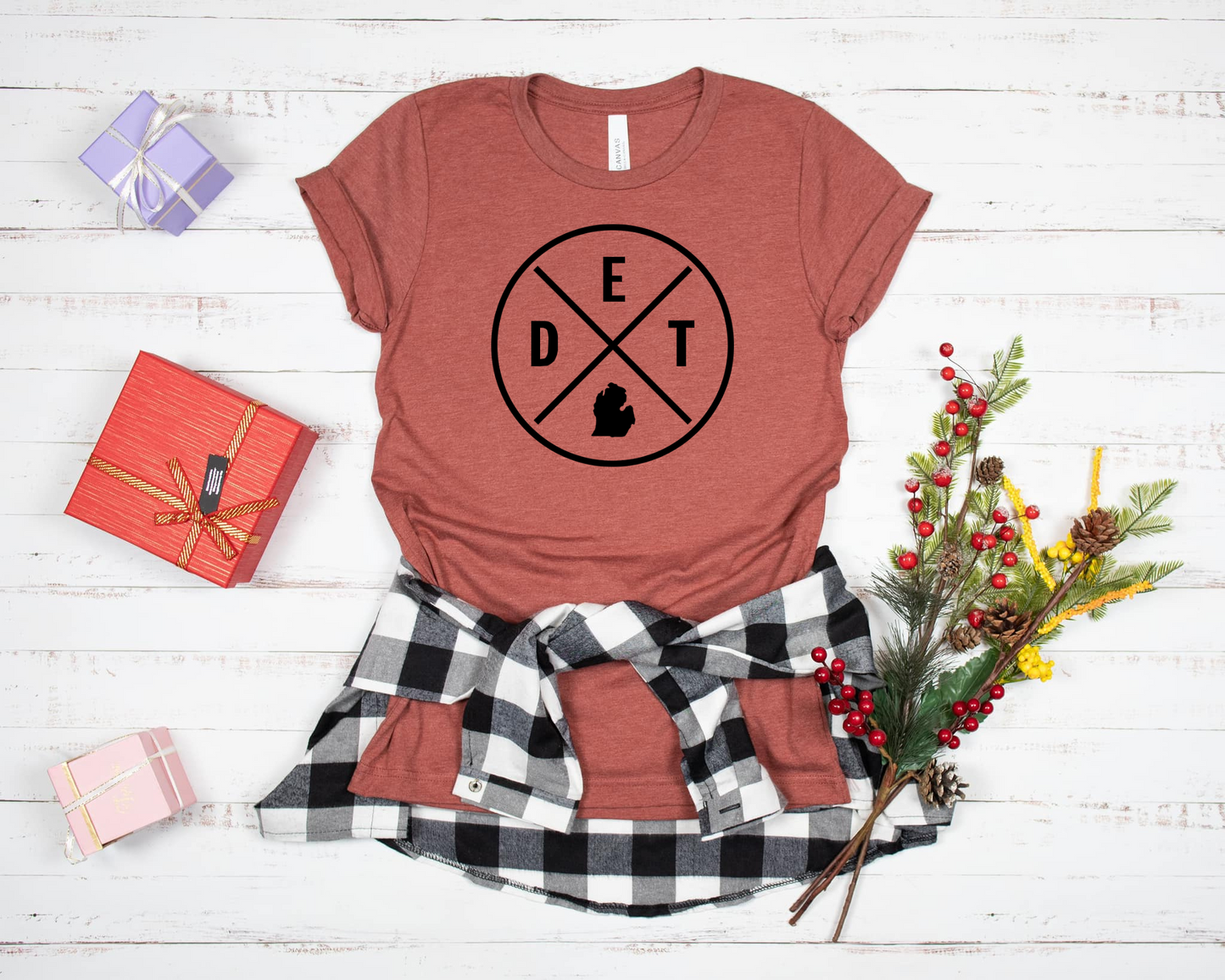 The DET MI Tee is a clay colored t-shirt that features a minimalist circular design with "DET" and the Michigan state silhouette inside a cross-lined emblem. A bold and simple way to represent Detroit or Michigan pride