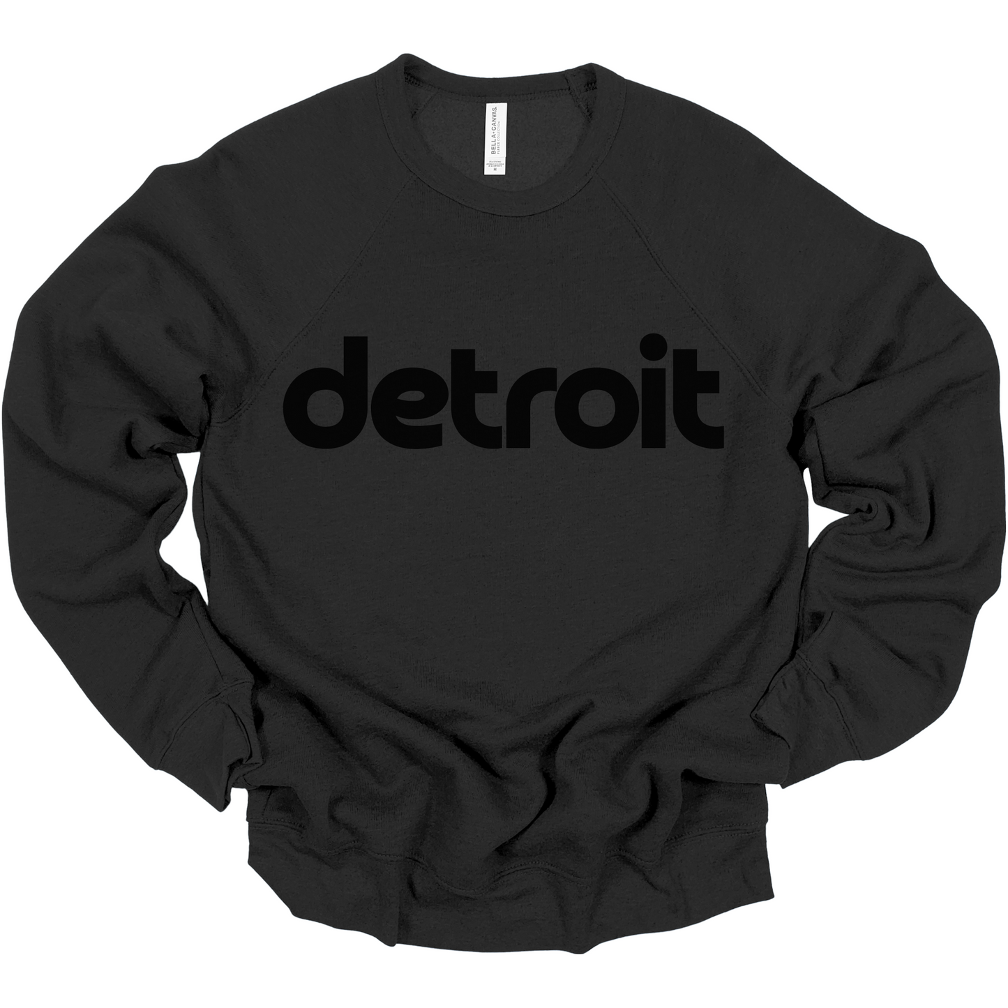 A black crewneck sweatshirt featuring the word 'detroit' in bold, modern black lowercase letters across the chest. The clean, minimalist design gives the sweatshirt a stylish and casual look, perfect for representing the Motor City in comfort and style