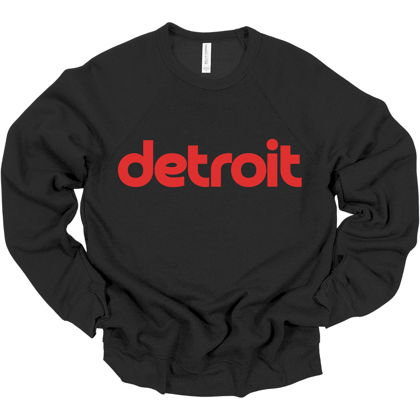 A black crewneck sweatshirt featuring the word 'detroit' in bold, modern red lowercase letters across the chest. The clean, minimalist design gives the sweatshirt a stylish and casual look, perfect for representing the Motor City in comfort and style