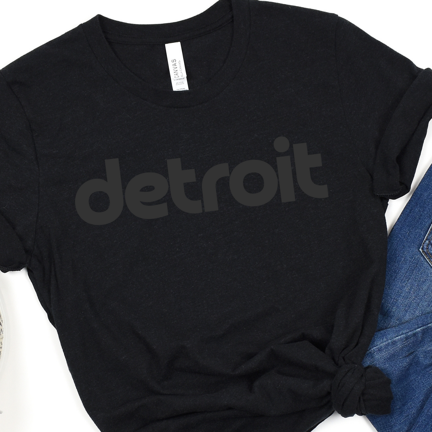 A black tee featuring the word 'detroit' in bold, modern black lowercase letters across the chest. The clean, minimalist design gives the sweatshirt a stylish and casual look, perfect for representing the Motor City in comfort and style