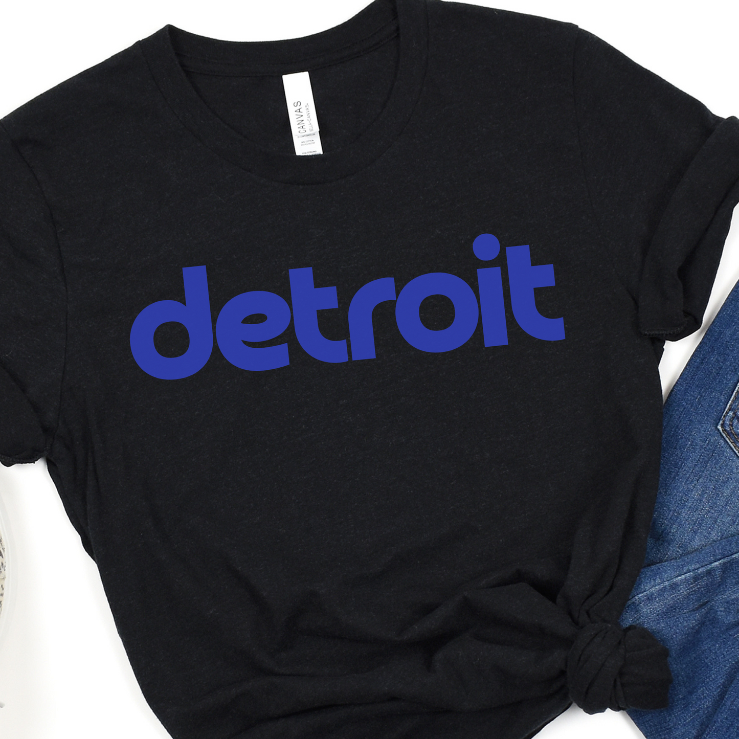 A black tee featuring the word 'detroit' in bold, modern blue lowercase letters across the chest. The clean, minimalist design gives the sweatshirt a stylish and casual look, perfect for representing the Motor City in comfort and style